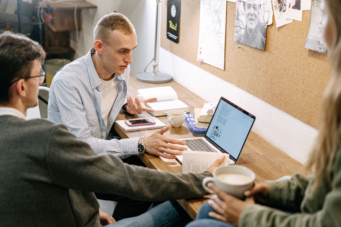 Learners collaborating with laptops and study notes — illustrative stock photo